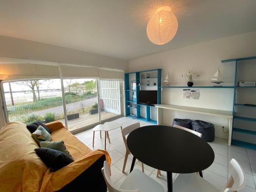 un salon avec un canapé et une table dans l'établissement Appartement 4 personnes, rez-de-chaussée, piscine, plage à 200 m, wifi - FR-1-709-32, à Fouras