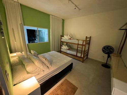 a bedroom with a bed with a green wall at Mar & Mata 511 in Ubatuba