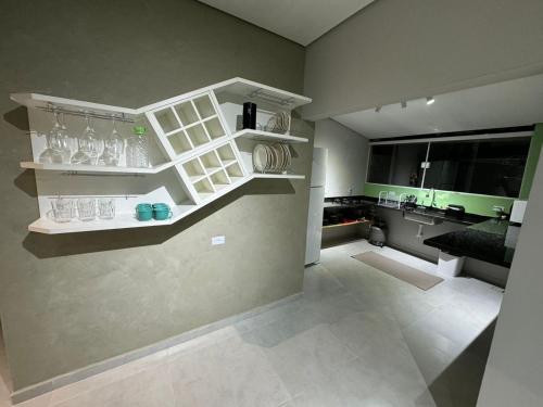 a kitchen with white shelves on the wall at Mar & Mata 511 in Ubatuba
