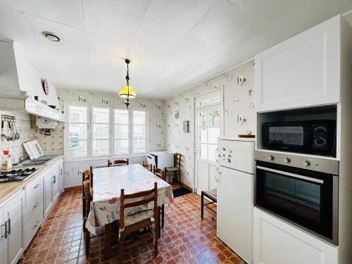 une cuisine avec une table et une salle à manger dans l'établissement Maison cosy à Fouras, proche plage, animaux acceptés - FR-1-709-80, à Fouras