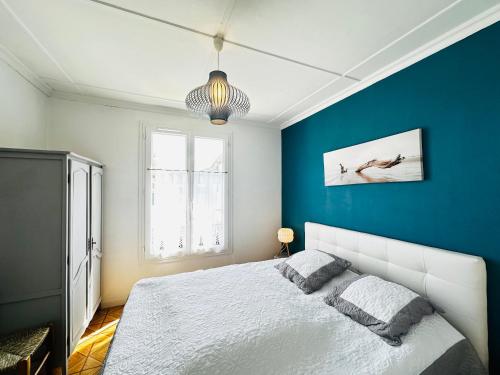 une chambre avec un mur bleu et un lit dans l'établissement Maison cosy à Fouras, proche plage, animaux acceptés - FR-1-709-80, à Fouras