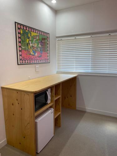 an office with a desk with a microwave and a counter at Traditional Apartment Takamatsu Guesthouse in Takamatsu