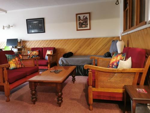 a living room with couches and chairs and a table at Spacious 2 bedroom apartment in Whangarei