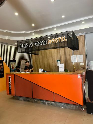 a happy bearossed restaurant with a man sitting at a counter at Happy Bear Hostel Phu Quoc in Phu Quoc