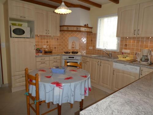 - une cuisine avec une table et des fleurs dans l'établissement Gîte calme proche plage et commerces au Croisic avec jardin, Wi-Fi, 4 chambres - FR-1-306-1308, au Croisic
