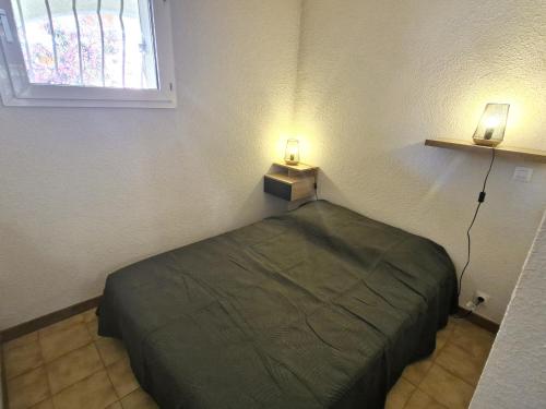 - une chambre avec un lit et deux lumières sur le mur dans l'établissement Appartement 2 pièces avec piscine, parking, animaux acceptés, Sainte-Maxime - FR-1-780-93, à Sainte-Maxime