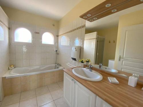 une salle de bain avec une baignoire et un lavabo et une baignoire dans l'établissement Maison charmante à 300m de la mer, Ile Grande, parking inclus - FR-1-368-458, à Pleumeur-Bodou