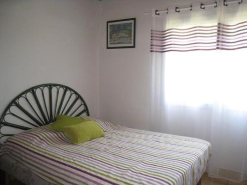 - une chambre avec un lit et une fenêtre avec un oreiller dans l'établissement Maison Noirmoutier calme, plage à 400m - FR-1-224B-244, à Noirmoutier-en-l'lle