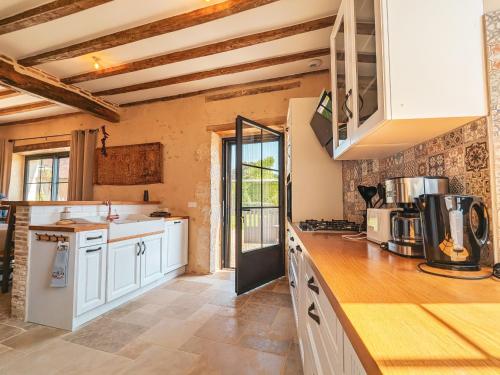 une cuisine avec des armoires blanches et un comptoir dans l'établissement Maison rénovée au cœur du Parc naturel de la Brenne, charme authentique - FR-1-591-734, à Pouligny-Saint-Pierre