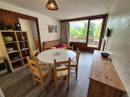 une salle à manger avec une table et des chaises et une fenêtre dans l'établissement Appartement 2 pièces, balcon sud, pieds de pistes, animaux admis - FR-1-811-40, à Les Deux Alpes