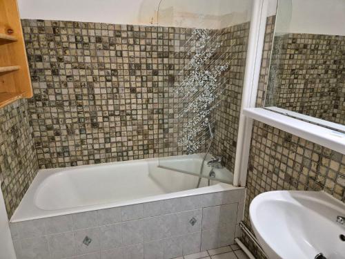 une salle de bain avec baignoire et toilettes dans l'établissement Appartement 2 pièces, balcon sud, pieds de pistes, animaux admis - FR-1-811-40, à Les Deux Alpes