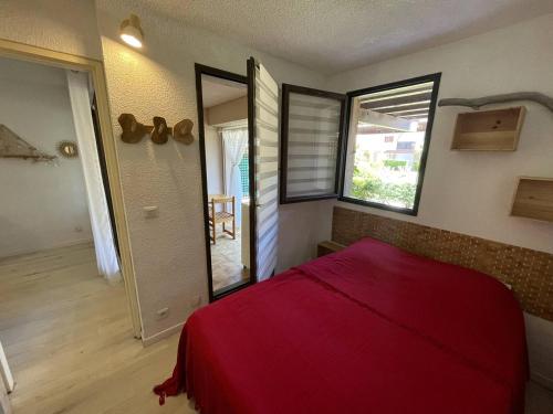 une chambre avec un lit rouge et un miroir dans l'établissement Appartement 2 pièces avec terrasse à Saint-Cyprien - FR-1-106-108, à Saint-Cyprien