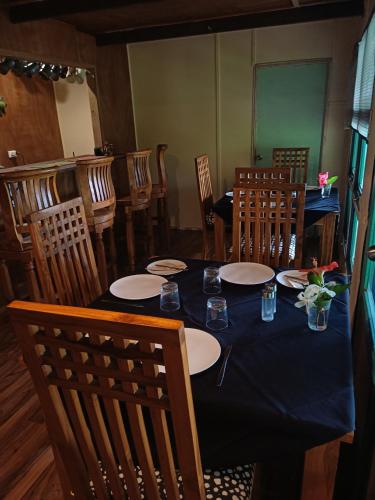 a dining room with a blue table and chairs at Mahina Lodge in Mafana