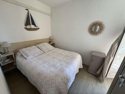 une petite chambre avec un lit et un miroir dans l'établissement T2 proche plage avec parking privatif, 4 personnes - FR-1-701-90, à Valras-Plage