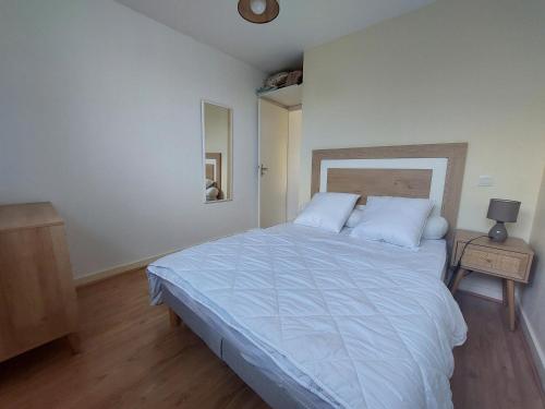 une chambre avec un grand lit avec des draps blancs dans l'établissement Appartement calme 4 pers, terrasse, parking privé - FR-1-550-91, à Saint-Georges-de-Didonne