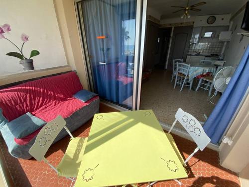 un salon avec un canapé rouge et une table dans l'établissement Studio front de mer équipé pour 3 personnes - FR-1-750-79, à Canet