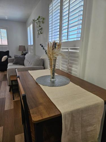 a dining room table with a vase of flowers on it at Newly Renovated Modern Studio in Oviedo