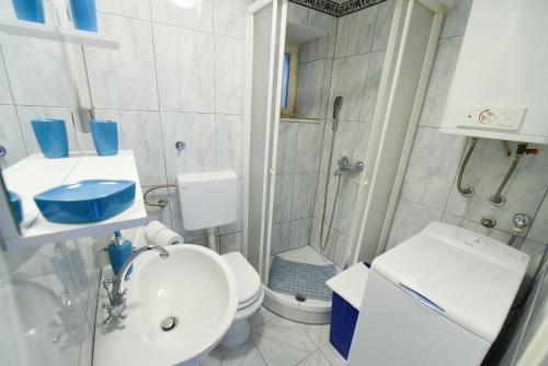 een badkamer met een douche, een toilet en een wastafel bij Apartment Duje in Split