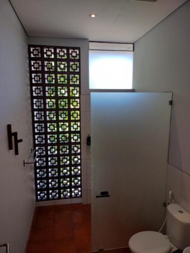 a bathroom with a toilet and a window at Nala's Home in Uluwatu