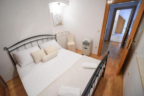 een slaapkamer met een groot wit bed met witte kussens bij Apartment Duje in Split