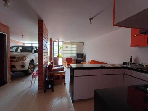 a kitchen with a car parked in a garage at CASA cerca a la ESTACIÓN del tren en PAIPA in Paipa