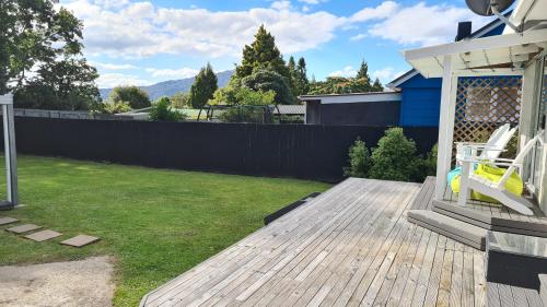 a backyard with a wooden deck and a fence at Hillcrest Hideaway in Rotorua