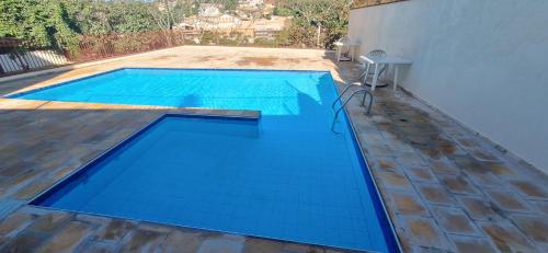 een groot blauw zwembad met een houten vloer bij apartamento águas de lindoia itaigara in Águas de Lindóia