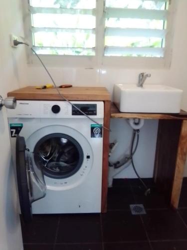 a washing machine in a bathroom with a sink at Waterfront modern 3br home Vale Ni Vonu in Nggathavulu