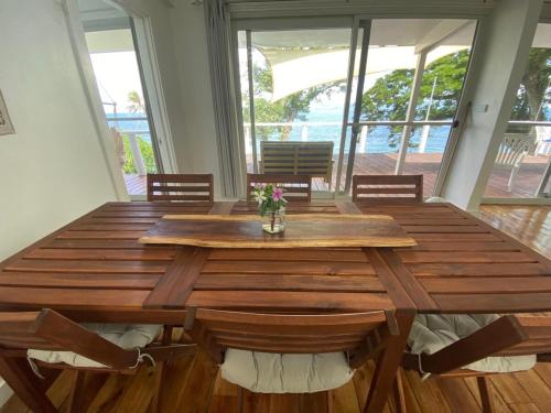 a wooden table in a room with a wooden floor at Waterfront modern 3br home Vale Ni Vonu in Nggathavulu