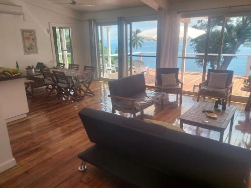 a living room with a couch and tables and chairs at Waterfront modern 3br home Vale Ni Vonu in Nggathavulu