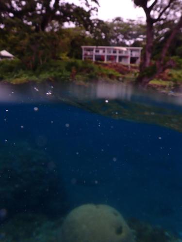 a pool of water with a house in the background at Waterfront modern 3br home Vale Ni Vonu in Nggathavulu