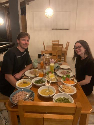 a man and woman sitting at a table full of food at Madiha Venus in Matara
