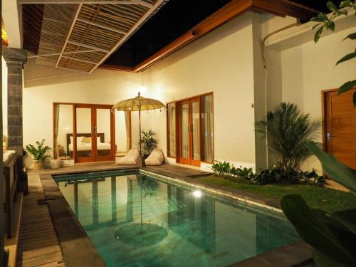a swimming pool in front of a house at MoHana Villa - A Minimal Canggu Oasis in Canggu