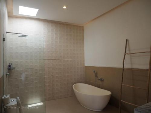 a bathroom with a tub and a sink and a shower at MoHana Villa - A Minimal Canggu Oasis in Canggu