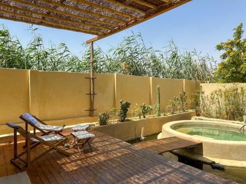 a patio with a table and a chair and a tub at Waterside Loft -Rustic & Lux Tunis Artisan Village in Tunis