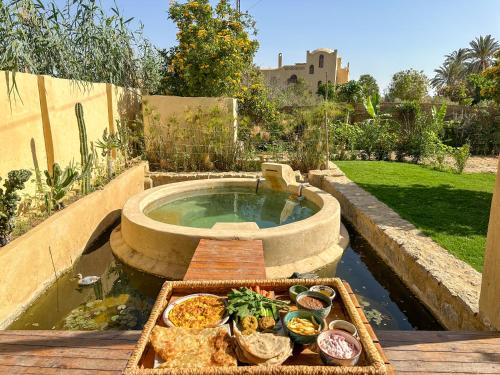 a tray of food sitting on a table next to a hot tub at Waterside Loft -Rustic & Lux Tunis Artisan Village in Tunis
