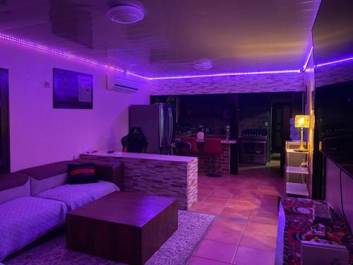 a living room with purple lighting and a couch at Charle's House in Jabillos