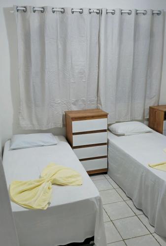 two beds sitting next to each other in a bedroom at Casa Cabugi Praia JR in Natal