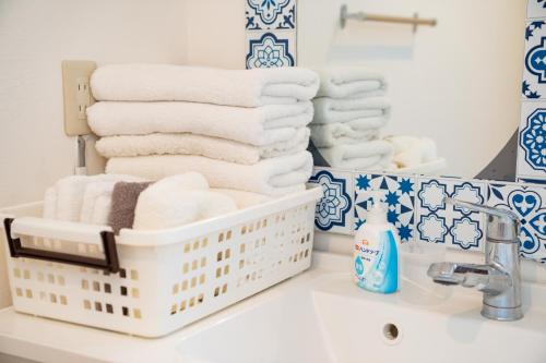 a bathroom with towels in a basket on a sink at ocean blue mint海まで３分! 南房総最南端の１棟まるごと貸別荘 in Hongō