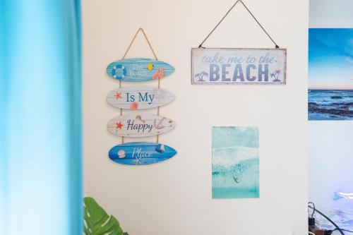a room with surfboards and a sign that reads welcome to the beach at ocean blue mint海まで３分! 南房総最南端の１棟まるごと貸別荘 in Hongō