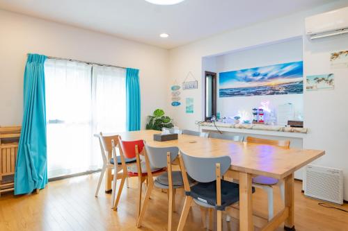 a dining room with a wooden table and chairs at ocean blue mint海まで３分! 南房総最南端の１棟まるごと貸別荘 in Hongō
