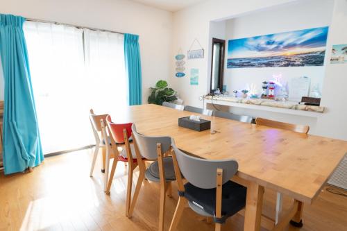 a dining room with a wooden table and chairs at ocean blue mint海まで３分! 南房総最南端の１棟まるごと貸別荘 in Hongō