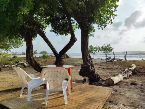 a table and chairs sitting on the beach at Casa Blanca Broqueles Hotel in Moñitos