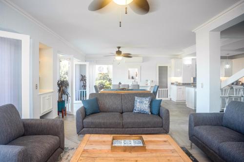 a living room with two couches and a kitchen at Oceanview 3BR Villa with 3 Shared Pools and Beachfront Resort Access in Ocotal