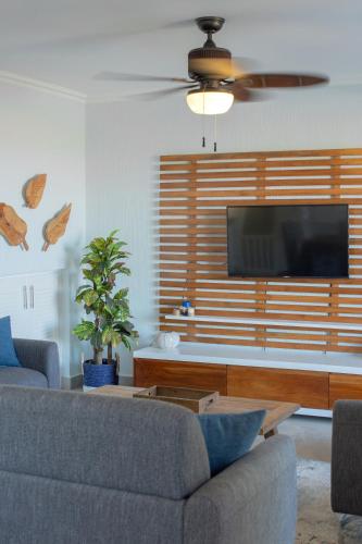 a living room with a couch and a flat screen tv at Oceanview 3BR Villa with 3 Shared Pools and Beachfront Resort Access in Ocotal