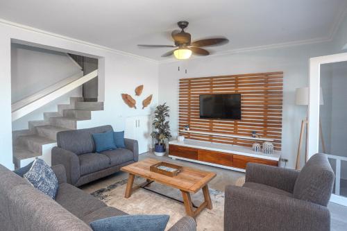 a living room with a couch and a tv at Oceanview 3BR Villa with 3 Shared Pools and Beachfront Resort Access in Ocotal