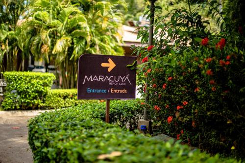 a sign in front of a bush with flowers at Oceanview 3BR Villa with 3 Shared Pools and Beachfront Resort Access in Ocotal