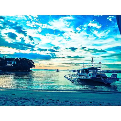 a boat is docked at a dock in the water at ZHANG RESORT and DIVE CENTER in Daanbantayan