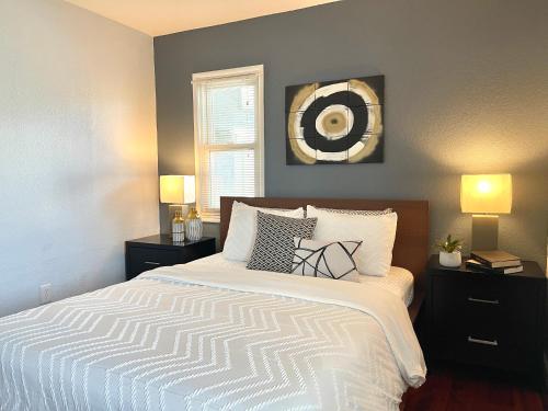 a bedroom with a bed with two lamps and a mirror at Lovely Home 30MIN to Berkeley, SF, Napa in Pinole