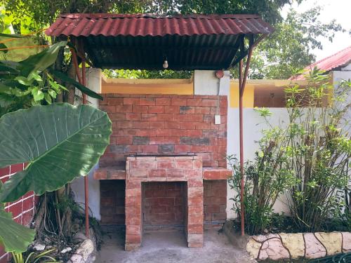 a brick fireplace with a roof on top of it at The Lighthouse Resort in Oslob
